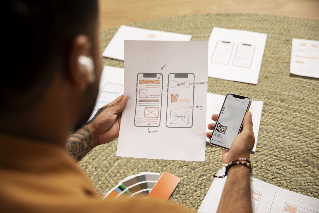 Um homem analisa um documento de papel com o protótipo de um aplicativo de celular, baseado em princípios de product-led design.