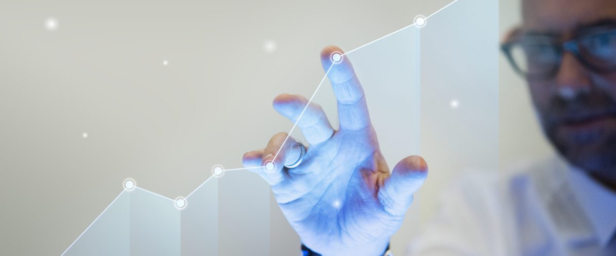 Businessman pointing his finger to a growth graph Businessman pointing his finger to a growth graph