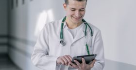 cheerful-young-doctor-using-tablet