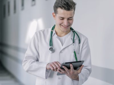 cheerful-young-doctor-using-tablet