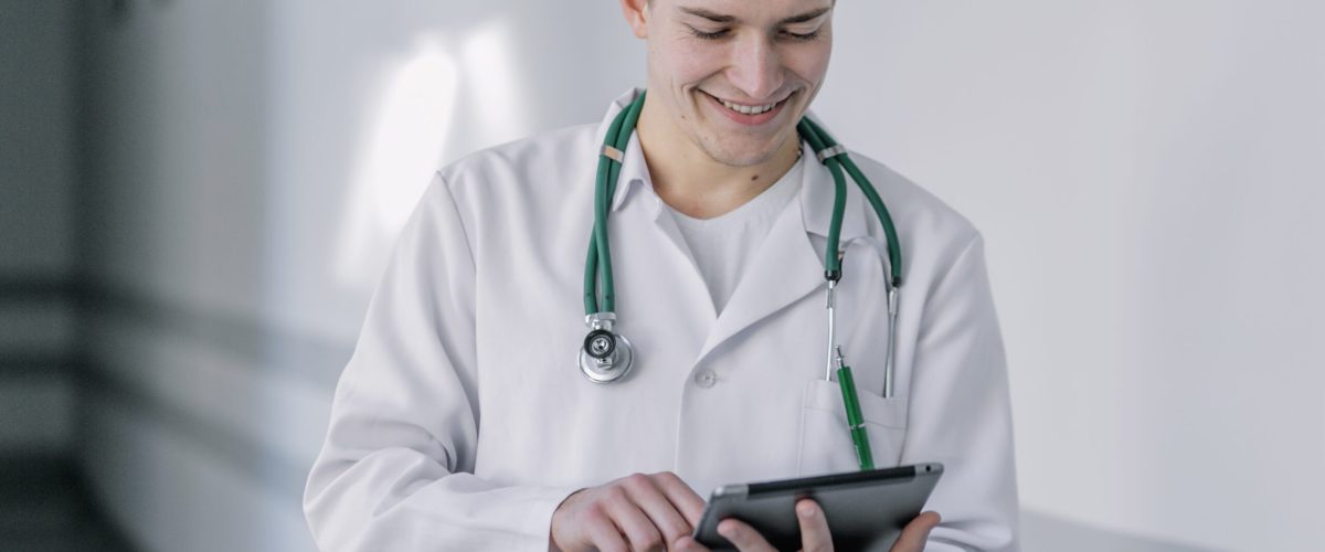 cheerful-young-doctor-using-tablet