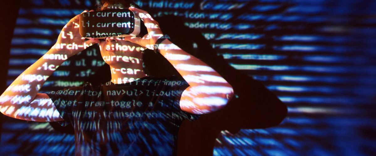 Double exposure of a caucasian man and Virtual reality VR headset is presumably a gamer or a hacker cracking the code into a secure network or server, with lines of code