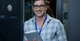 Engineer, server room and portrait of a man with a tablet for programming, cybersecurity or maintenance. Technician person in a datacenter for network, software or system upgrade app with technology.