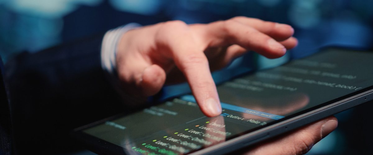 Male system administrator inspecting big data on tablet, working in modern data center. Infrastructure specialist inspecting server rack systems, artificial intelligence. Handheld shot. Close up.