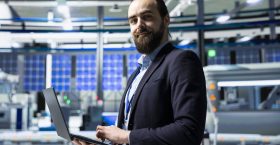 Solar panel industry expert stands in a high tech facility for inspection, quality control production metrics. Professional consultant ensuring industrial operations for innovation.