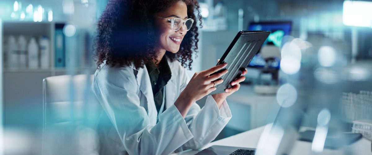 Tablet, laptop and woman scientist in lab working on medical research, project or experiment. Science, career and female researcher with digital technology and computer for pharmaceutical innovation